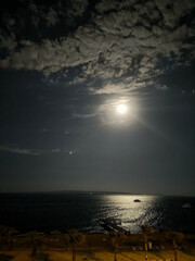 Full moon in the night sky. Moon path on the sea. Yachts at anchor. Night. Autumn. Egypt.