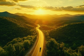 Fototapeta premium Aerial view of a winding road in the mountains. This photo is perfect for representing travel, adventure, and the beauty of nature.