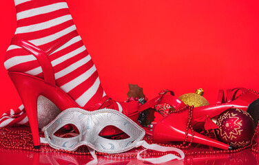 woman's leg in red stiletto sandal next to christmas tree decorations