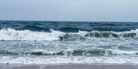 Fototapeta premium Dynamic and powerful sea water wave crashing against the shore under a cloudy sky, storm, dramatic, aquatic