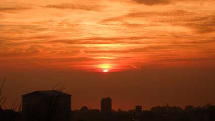 Close-up of an orange cloudy sunset above buildings