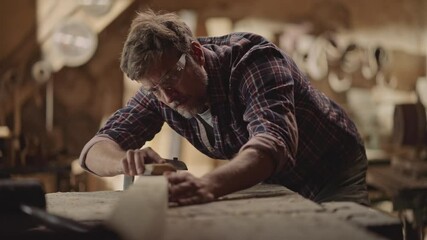 Sandpaper is sanding wood on work bench, as a experienced carpenter moving it around in slow-motion
