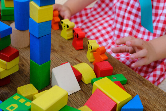 girl plays role-playing games with wooden figurines, figures, blocks, kindergarten games, concept of childhood, earlier child development, creativity, early training