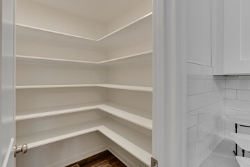 Empty Pantry With White Shelves And Ample Storage Room.