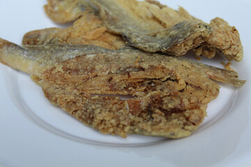 Fried fish. Preserved fish by salting method, half cut, flour coated, called Gereh or Ikan Asin in Indonesia. Isolated on white background