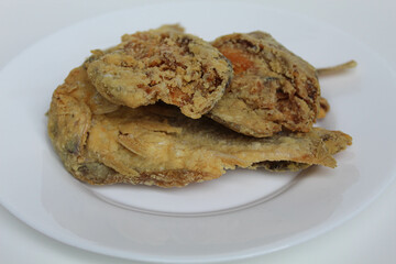 Fried fish. Preserved fish by salting method, half cut, flour coated, called Gereh or Ikan Asin in Indonesia. Isolated on white background
