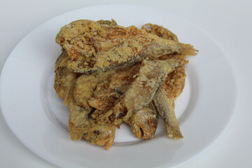Fried fish. Preserved fish by salting method, half cut, flour coated, called Gereh or Ikan Asin in Indonesia. Isolated on white background
