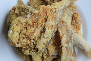 Fried fish. Preserved fish by salting method, half cut, flour coated, called Gereh or Ikan Asin in Indonesia. Isolated on white background