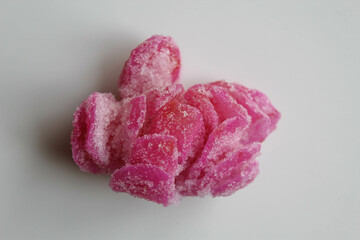 Manisan Pala, or candied nutmeg fruit, snack from Indonesia. In flower shaped, dried, covered by crystal sugar, isolated on white background