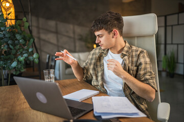 Focused young adult man write notes in notebook prepare for exam