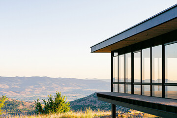 Fototapeta premium a contemporary glass house with steel frame, mountain backdrop