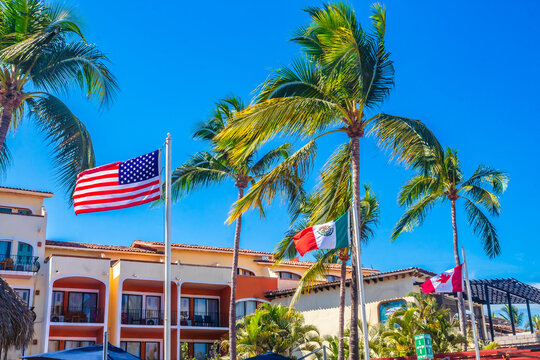 Flags of Mexico, Canada and the United States of America in the tropical zone in Puerto Vallarta, Jalisco, on the facade of a hotel 