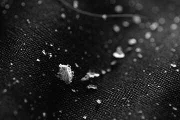 Macro shot of dandruff flakes on black cloth