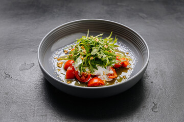 Fresh arugula and burrata salad with cherry tomatoes, nuts, and olive oil drizzle for gourmet touch