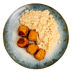Small portion of oatmeal complements round fried albondigas meatballs made from ground beef with addition of spicy spices. Isolated over white background