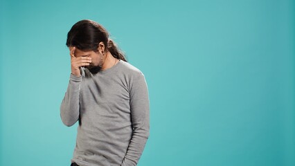 Portrait of troubled man feeling saddened and rattled by bad news, isolated over studio backdrop. Distressed person on the verge of crying, left speechless by troubling events, camera B