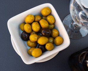 Delicious appetizer made from Greek olives. Black and green olives in a plate side view