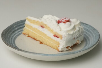 One small Japanese strawberry shortcake on a stylish Japanese plate on a white table