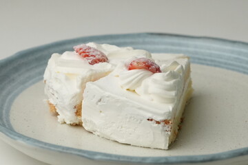 Two Japanese strawberry shortcakes on a stylish large plate on a white table