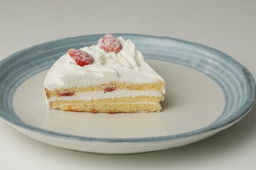 Two Japanese strawberry shortcakes on a stylish large plate on a white table
