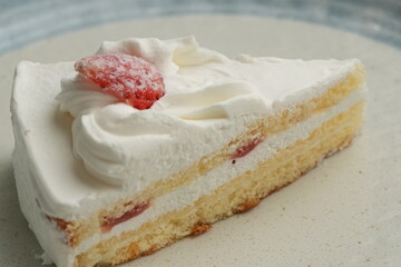 One small Japanese strawberry shortcake on a stylish large plate on a white table