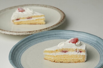 Two Japanese strawberry shortcakes on a stylish large plate on a white table