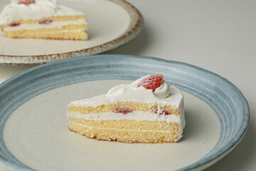 Two Japanese strawberry shortcakes on a stylish large plate on a white table