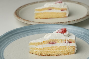 Two Japanese strawberry shortcakes on a stylish large plate on a white table