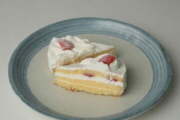 Two Japanese strawberry shortcakes on a stylish large plate on a white table