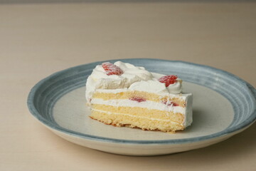 Two Japanese strawberry shortcakes on a stylish large plate on a wooden table