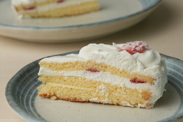 Japanese strawberry shortcake on each stylish large and small plate on a wooden table