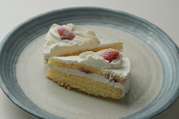 Two Japanese strawberry shortcakes on a stylish large plate on a white table