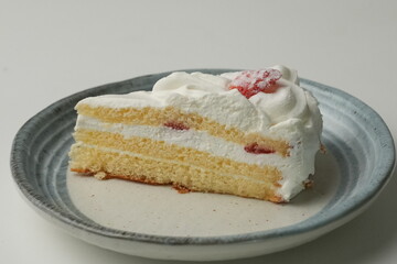 One small Japanese strawberry shortcake on a stylish Japanese plate on a white table