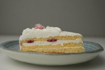 One small Japanese strawberry shortcake on a stylish Japanese plate on a white table