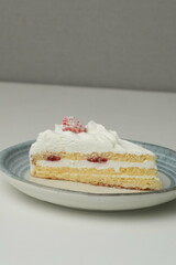 One small Japanese strawberry shortcake on a stylish Japanese plate on a white table