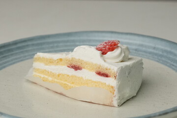 One small Japanese strawberry shortcake on a stylish Japanese plate on a white table