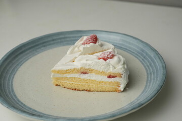 Two Japanese strawberry shortcakes on a stylish large plate on a white table