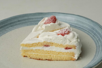 Two Japanese strawberry shortcakes on a stylish large plate on a white table