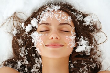 A serene woman is lying on the fresh snow, eyes closed with a peaceful smile, conveying tranquility and a connection with nature during winter.