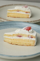 Two Japanese strawberry shortcakes on a stylish large plate on a white table