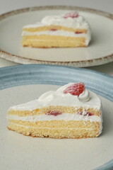 Two Japanese strawberry shortcakes on a stylish large plate on a white table