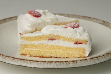 Two Japanese strawberry shortcakes on a stylish large plate on a white table