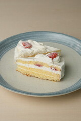 Two Japanese strawberry shortcakes on a stylish large plate on a wooden table