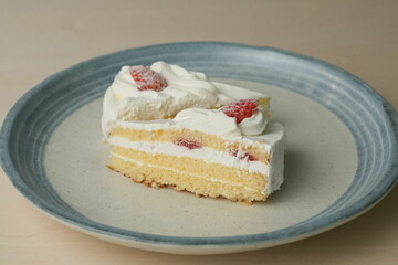 Two Japanese strawberry shortcakes on a stylish large plate on a wooden table