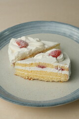 Two Japanese strawberry shortcakes on a stylish large plate on a wooden table