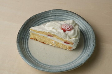 Japanese strawberry shortcake on each stylish large and small plate on a wooden table