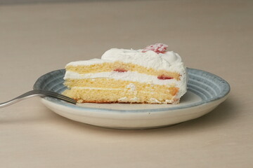Japanese strawberry shortcake and fork on each stylish large and small plate on a wooden table