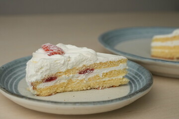 Japanese strawberry shortcake on each stylish large and small plate on a wooden table