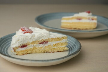 Japanese strawberry shortcake on each stylish large and small plate on a wooden table