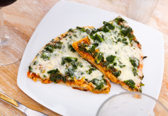 Appetizing pizza with tender greens of spinach and cheese